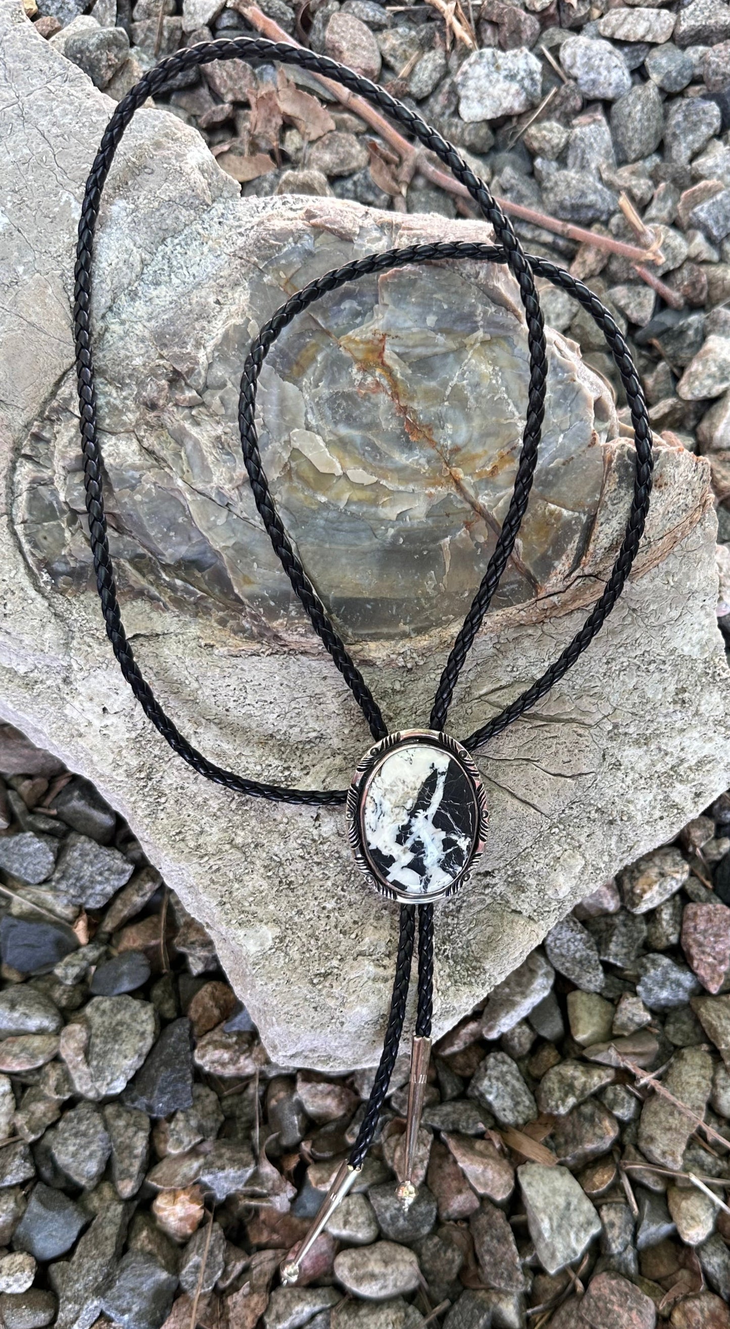 Necklace with a circular pendant on a stone surface with gravel background