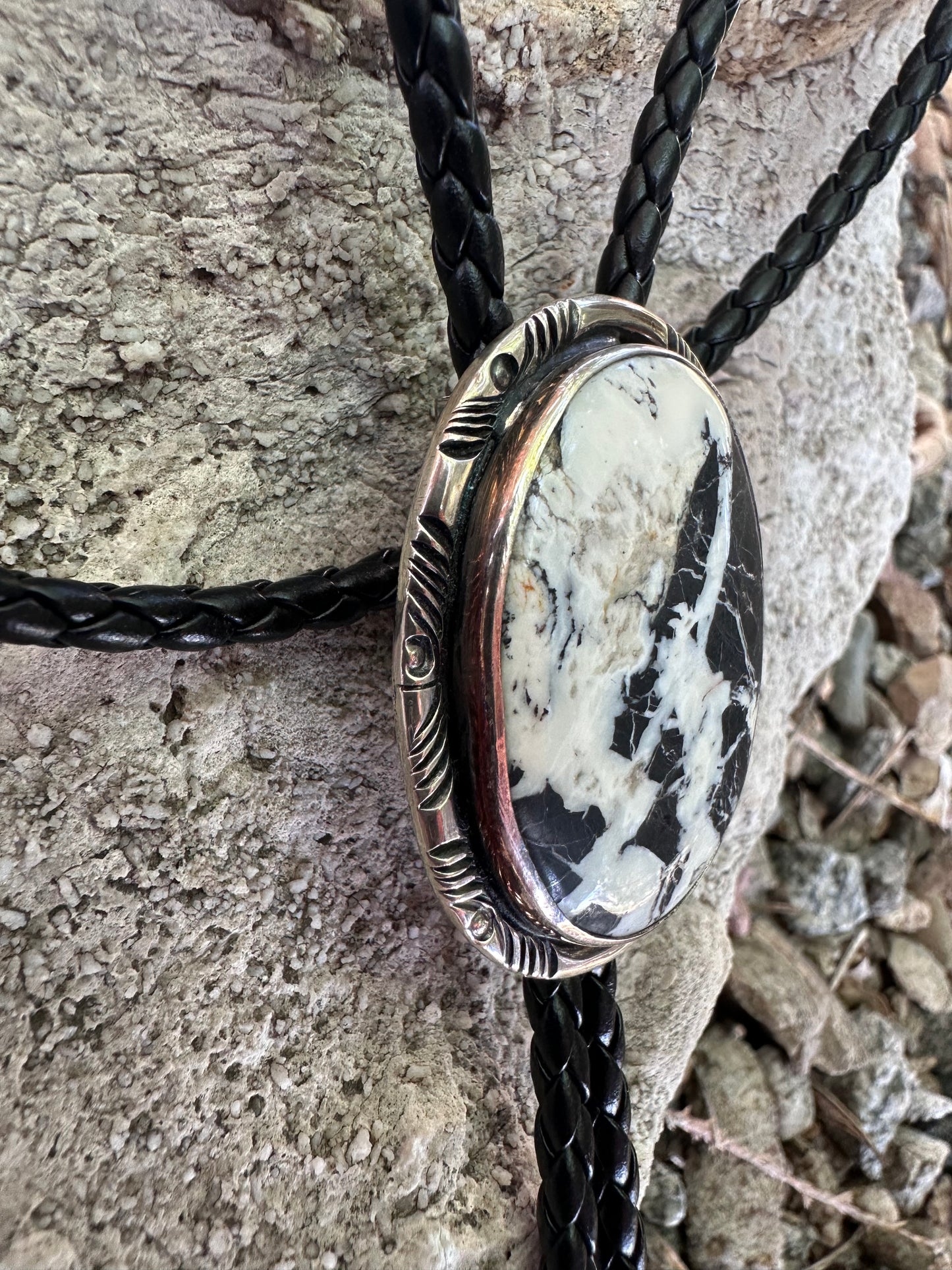 Bolo tie with stone centerpiece on a rock surface