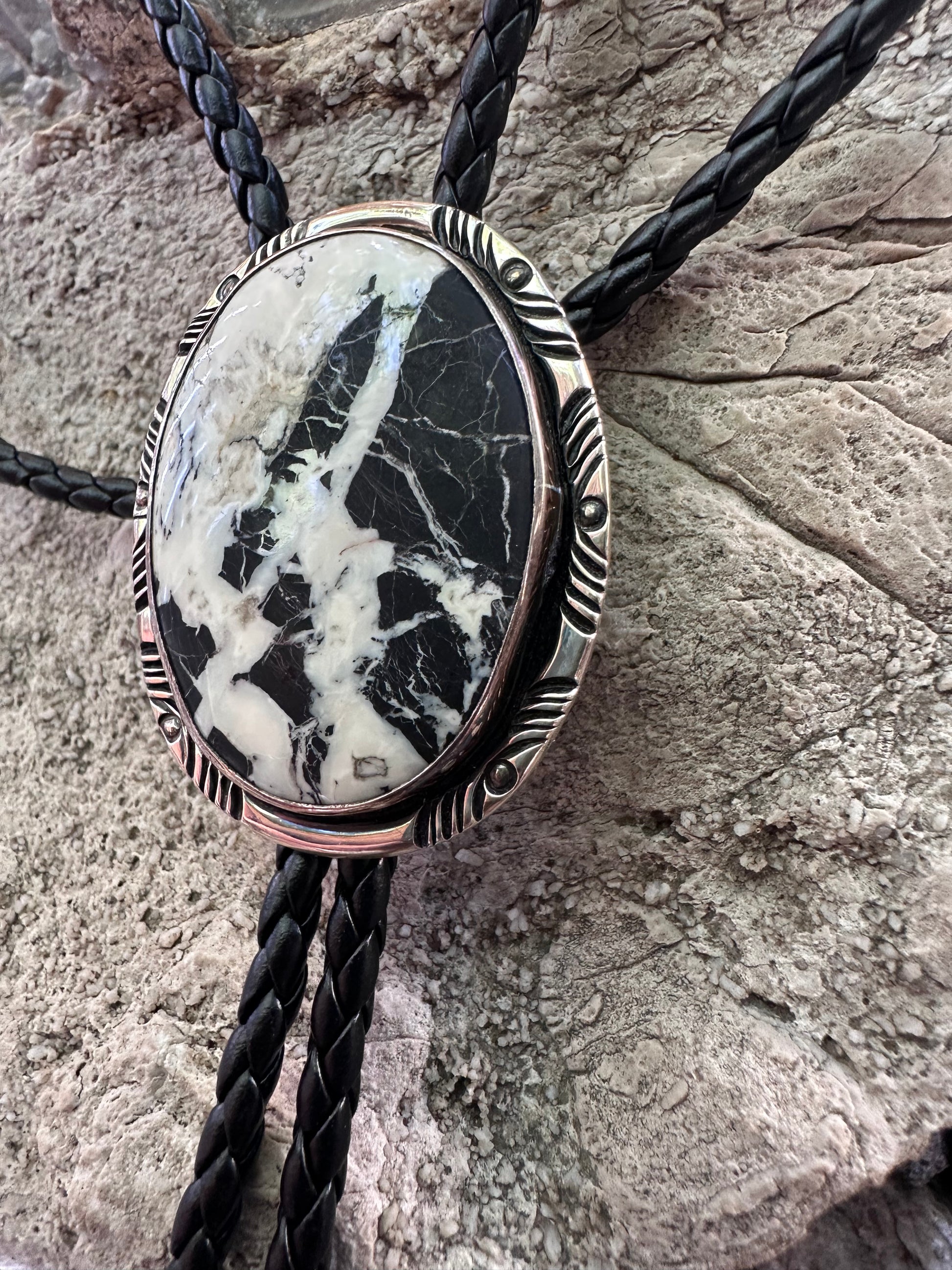 Bolo tie with a stone pendant on a textured surface